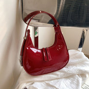 Schultertasche in Halbmondform mit verstellbarem Gurt und Reißverschlusstaschen